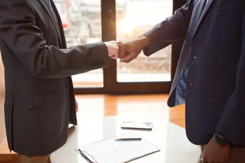 Two man shaking each others hands after signing papers. Stock Photos
