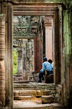 Two man sitting between stone doors Stock Photos