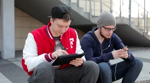 Two man sitting on the wall with tablet. Stock-Footage 49535616