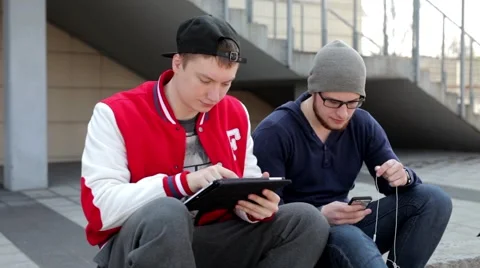 Two man sitting on the wall with tablet. Stock Footage 49535623