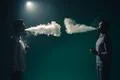 The two man smoke an electrical cigarette on the dark background Photo