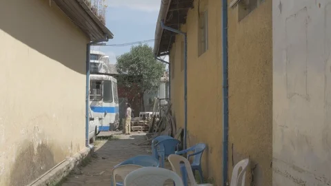 Two man standing and talking in a compound Stock Footage 108476826