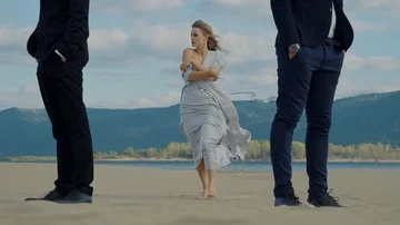 Two man standing on a beach and a woman Video stock 85703083