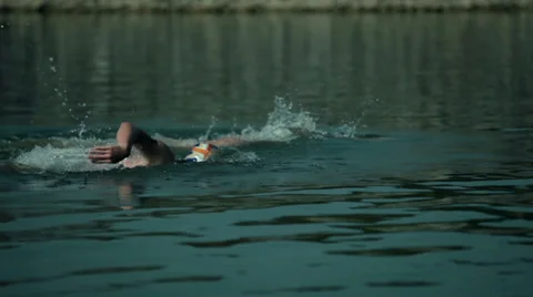 Two man swimming side by side in lake Stock Footage