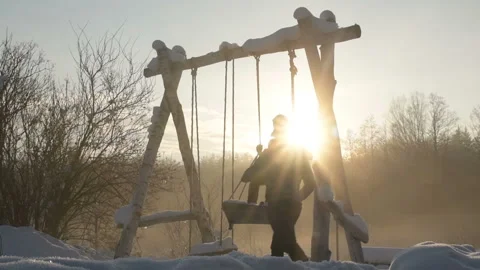 Two man swinging on a rope swing in a snowy winter. Video stock 147223965