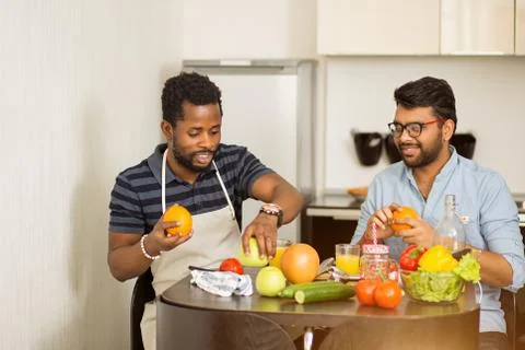 Two man using laptop in kitchen Stock Photos