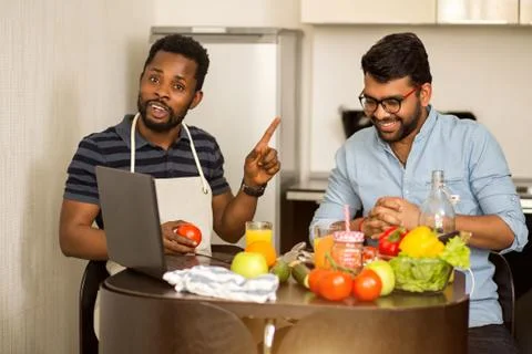 Two man using laptop in kitchen Stock Photos