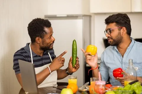Two man using laptop in kitchen Stock Photos
