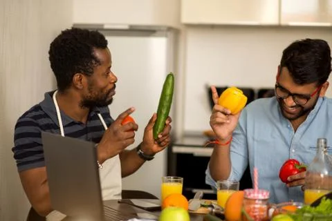 Two man using laptop in kitchen Stock Photos