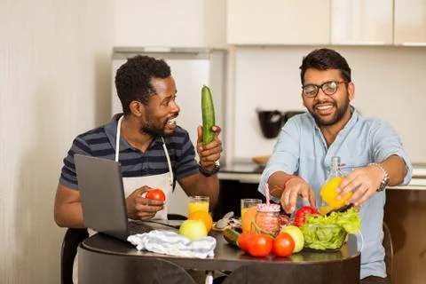 Two man using laptop in kitchen Stock Photos