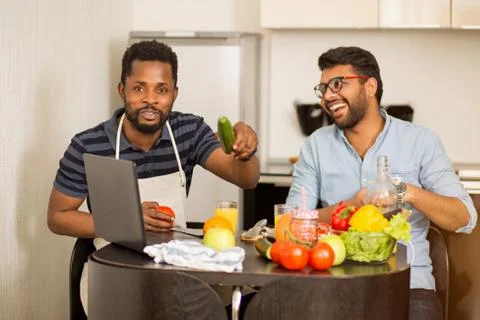 Two man using laptop in kitchen Stock Photos
