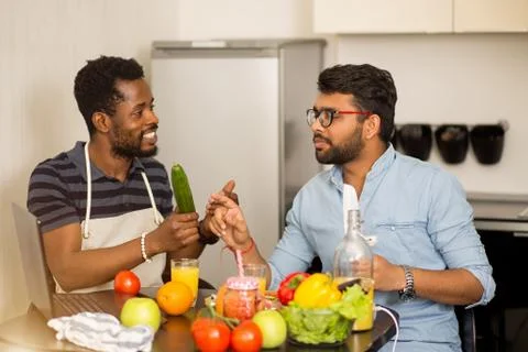 Two man using laptop in kitchen Stock Photos