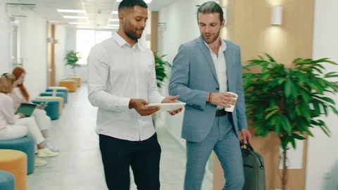 Two managers with beards are walking and talking through the office halls, they Stock Footage 166909643