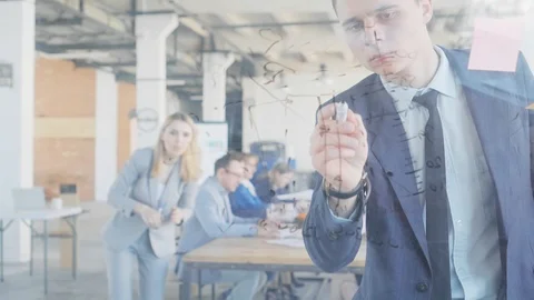 Two managers, a man and a woman, draws graphics on a glass board with a marker Stock Footage 108977109