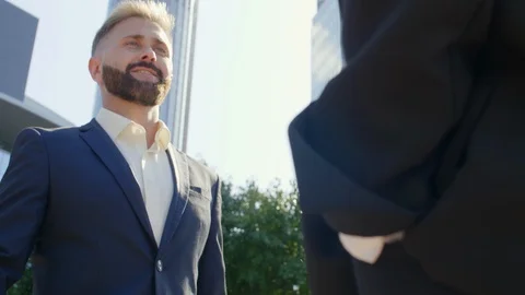 Two managers shaking hands outside skyscraper Video stock 120664503
