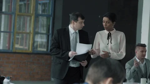Two managers, a woman and a man walk in the office and discuss the project Stock Footage 124274372