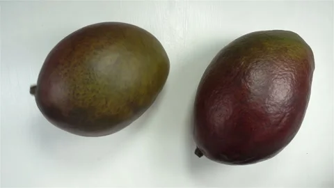 Two mango fruit rotates in slow motion Stock Footage 142003017