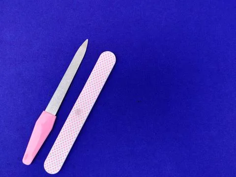 Two manicure tools isolated on blue background. Copy space Stock Photos