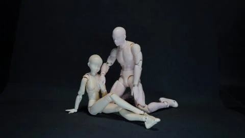 Two mannequin art models representing a romantic embrace on black background Stock Photos