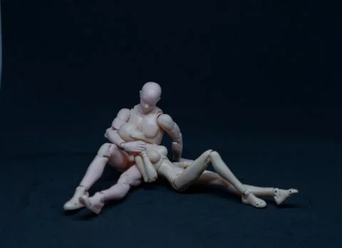 Two mannequin art models representing a romantic embrace on black background Stock Photos