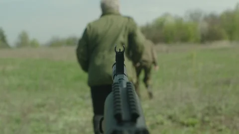 Two mans are running  on the field. They are under the gun. Stock Footage 107794109