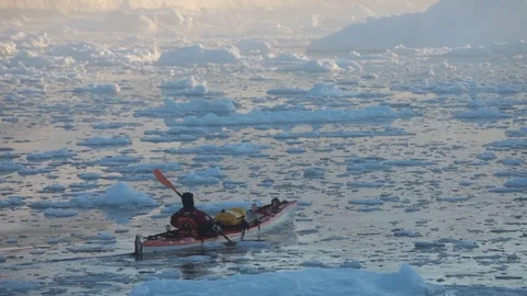 Two mans moving on kayaks moving in the middle of Arctic Ocean, Greenland Video stock 100872097
