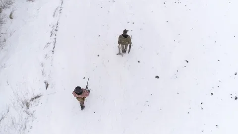 Two mans in a winter camouflage. One carries in her hand a dead rabbit. 스톡 동영상 123200685