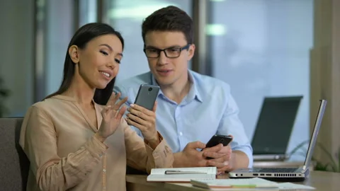 Two marketers testing work of new mobile app on smartphone, software engineering Stock Footage 102901128