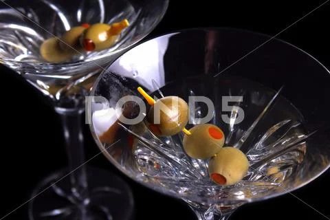 Two martini glasses with olives Stock Photos