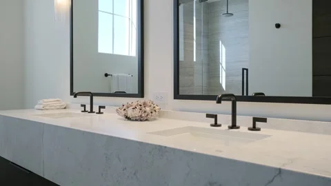 Two massive white marble sinks equipped with matte black sanitary ware with Stock-Footage 265173388