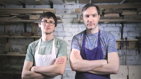 Two master carpenter in an apron in his workshop. Small business Stock Footage 102567389