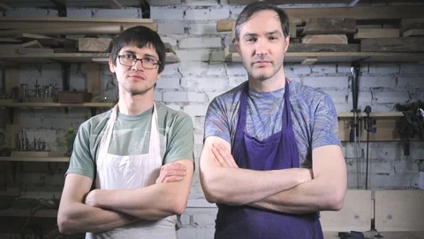 Two master carpenter in an apron in his workshop. Small business Stock Footage 102567479