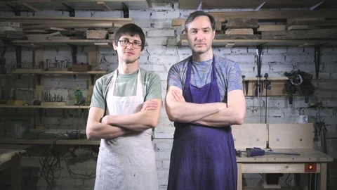 Two master carpenter in an apron in his workshop. Small business Stock Footage 102567483