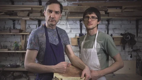 Two master carpenter in an apron in his workshop. Small business Stock Footage 102568136
