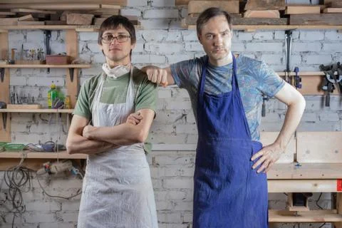 Two master carpenter in an apron in his workshop. Small business Stock Photos
