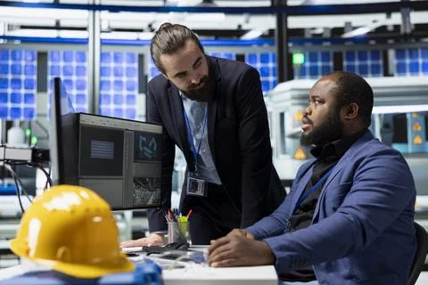 Two master engineers gather in a solar panel facility to monitor process flow 写真素材