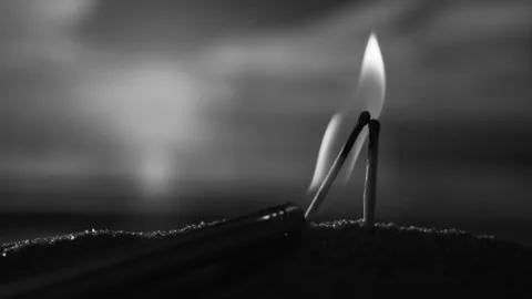 Two matches burn in the setting sun like a couple kissing,black and white Stock Footage 195400452