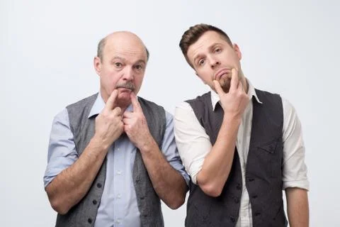 Two mature men father and son being sad. Negative facial emotion Stock Photos