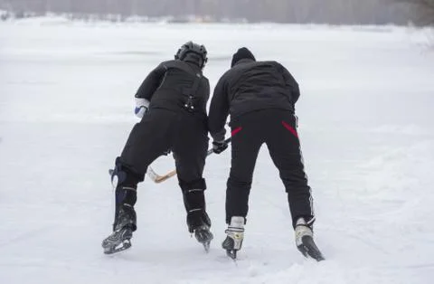 Two mature men fighting while playing hockey Stock Photos