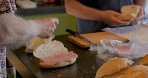 Two mature men making ham and cheese sandwiches together Stock Footage 95127307