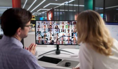 Two Mature Professionals Managing Remote Teams In Virtual Conference Meeting. Stock Photos