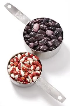 Two measuring cups with kidney beans, white background 스톡 사진