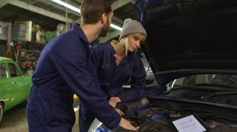 Two mechanic fixing a car in a workshop  Stock Footage 46308850