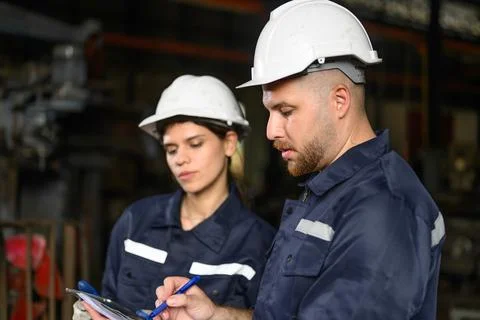 Two mechanical engineer in white hard hat talking Stock Photos