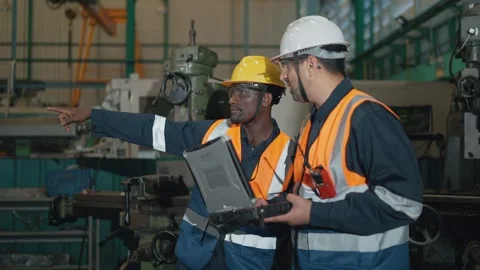 Two mechanical engineers using an laptop to set up system operations in factory. Vídeos de archivo 330398062