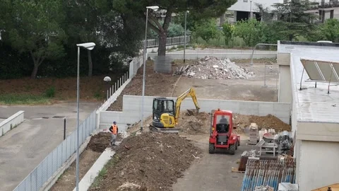 Two mechanical vehicles work on a construction site Stock Footage 243550486