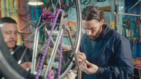 Two Mechanics Assembling Parts of New Bike in Workshop Stock-Footage 256590830
