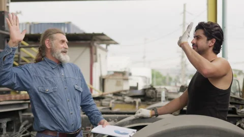 Two mechanics celebrate with a high five after completing a successful vehicle Stock Footage 333779858