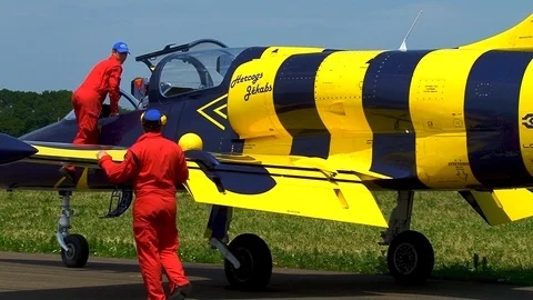 Two mechanics in red overalls inspect L-39 aircraft after flight. Stock Footage 106772133