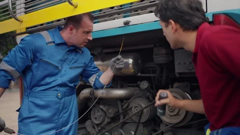 Two mechanics work side by side on a large vehicle engine Stock-Footage 347769652